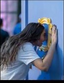 Community member painting a blue AT&T mural